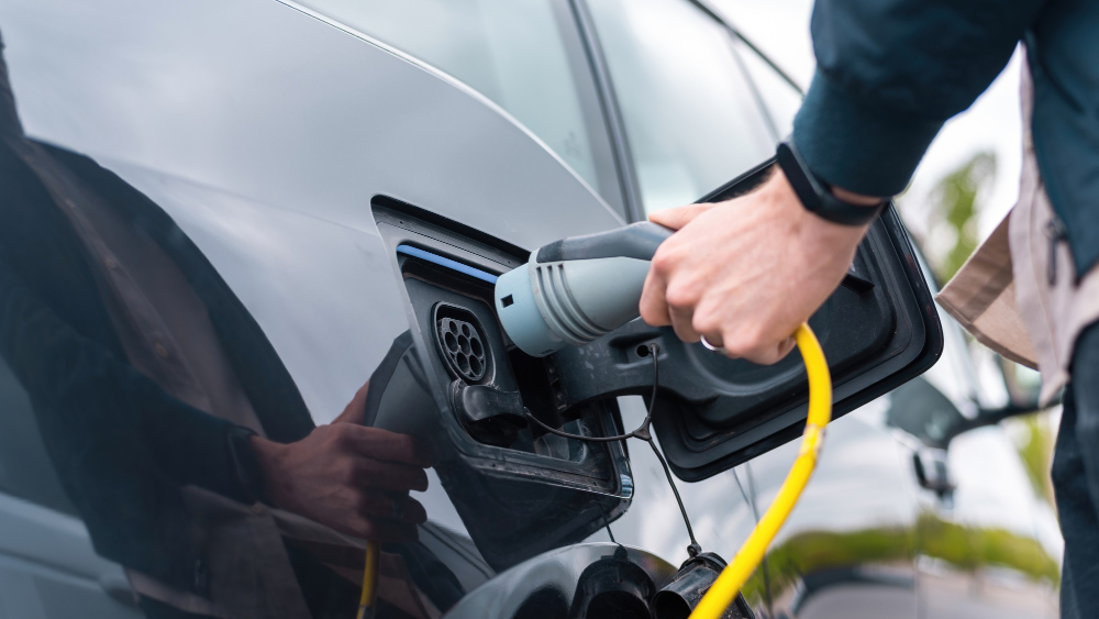 Homme branchant chargeur dans voiture électrique